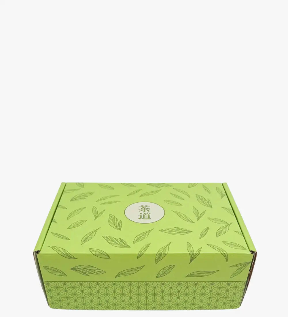 Limegrön kartonglåda prydd med ett upprepat bladmönster och med de kinesiska tecknen ’茶道’ i ett centralt cirkulärt emblem.