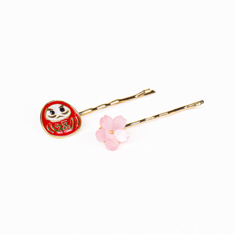 Japanska hårspännen med Daruma- och Sakura-motiv