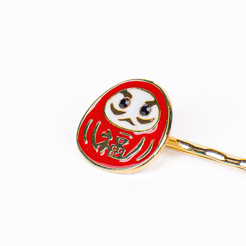 Japanska hårspännen med Daruma- och Sakura-motiv