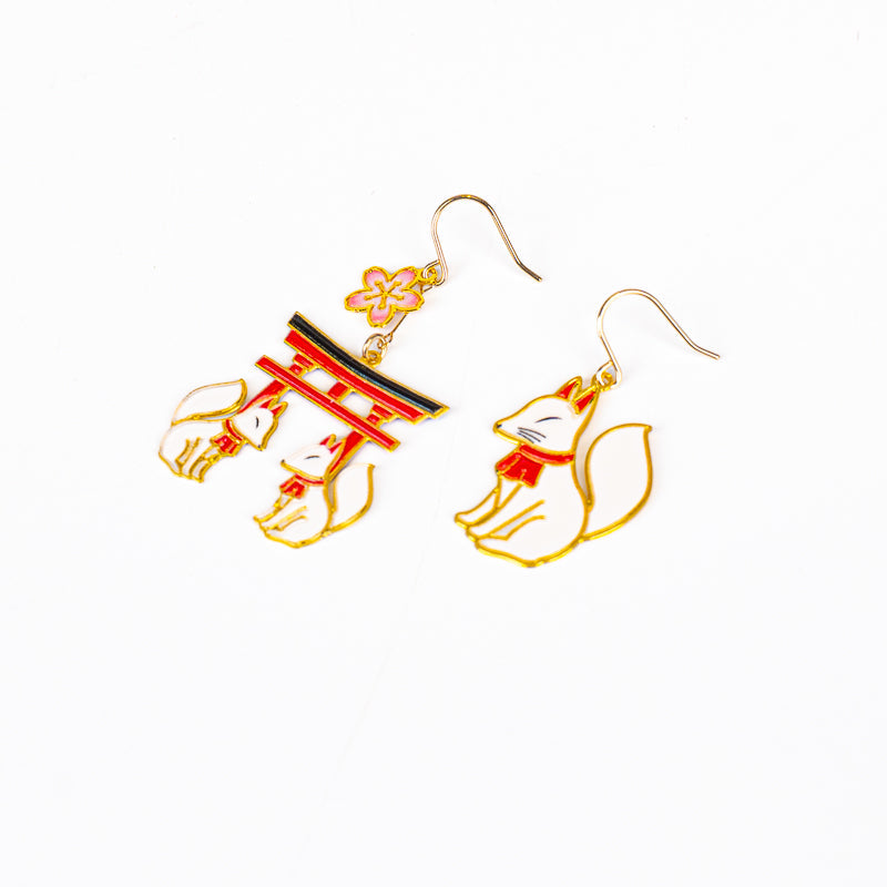 Japanska örhängen med motiv av torii och kitsune