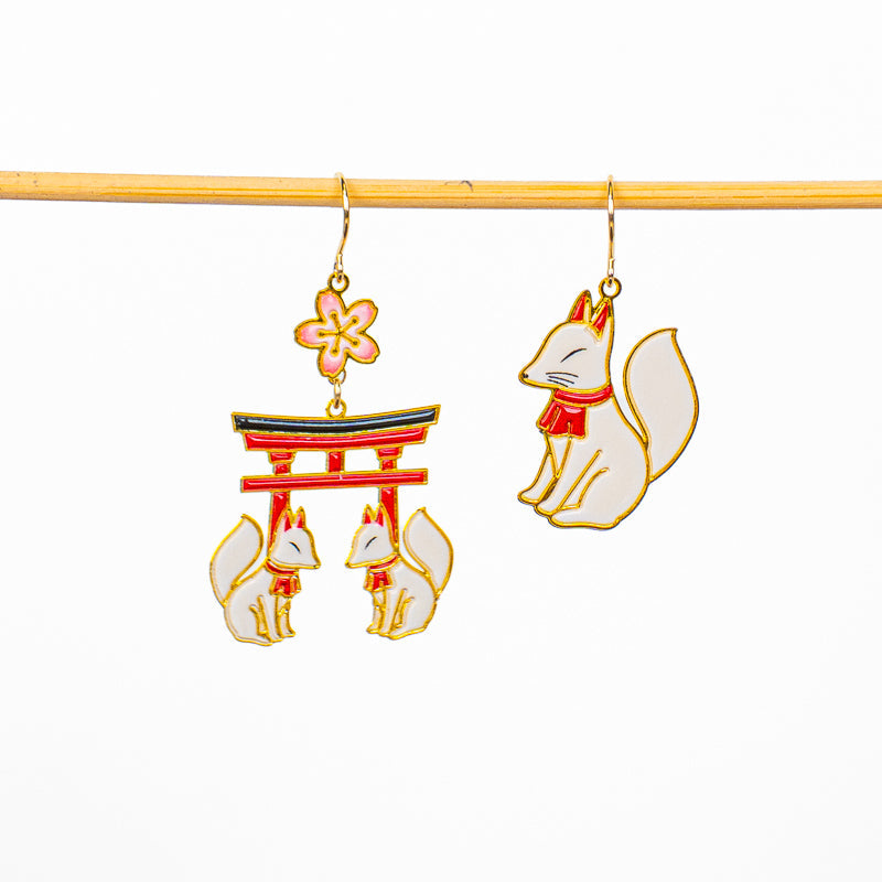 Japanska örhängen med motiv av torii och kitsune