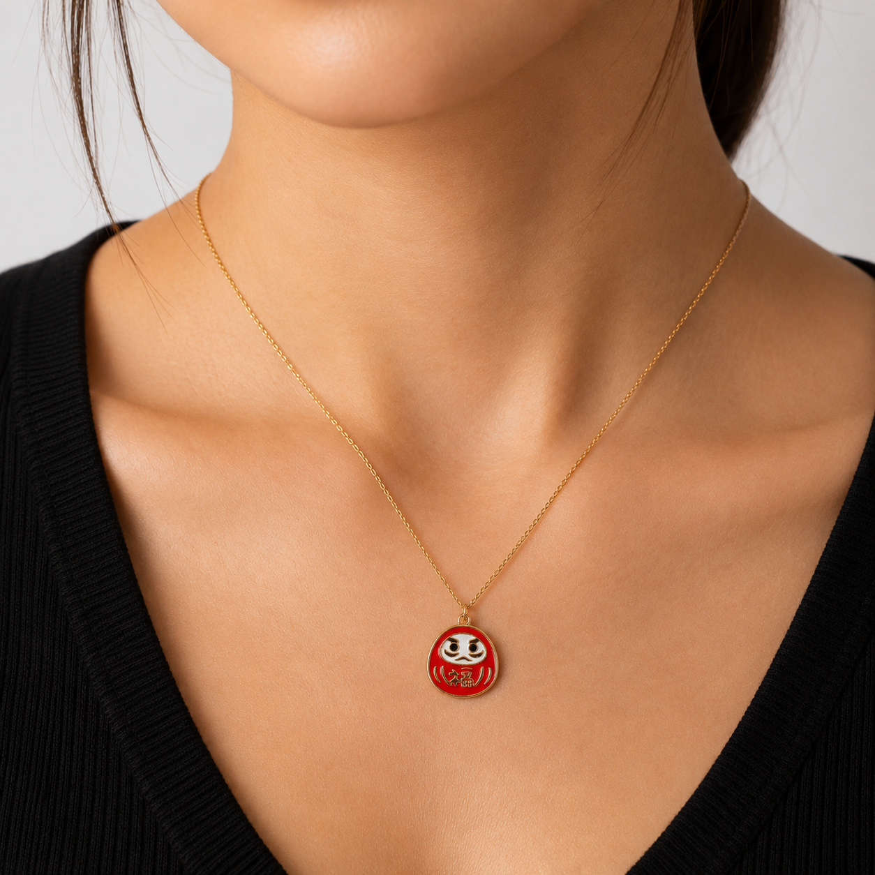 Japanskt halsband med rött och guldfärgat Daruma-hänge