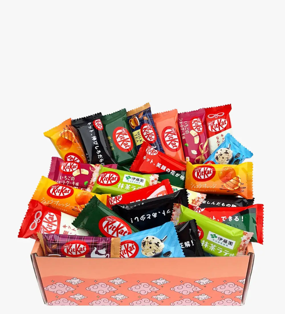 En livlig samling av KitKat chokladstänger i färgglada, blandade förpackningar som ligger i en rosa mönstrad presentlåda.